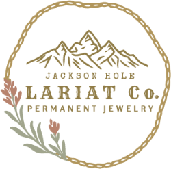 Logo of Jackson Hole Lariat Co. with mountains and floral elements on a white background